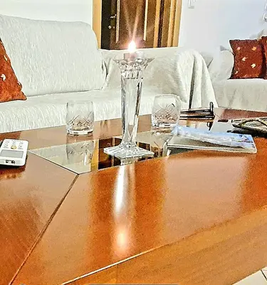 a living room with a table with a candle on it at Aqua Apartment Kallithea Athens in Athens