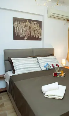 a bed with two towels on it in a room at Aqua Apartment Kallithea Athens in Athens