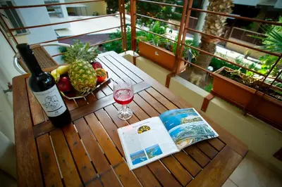 a wooden table with a bottle of wine and a book at Aqua Apartment Kallithea Athens in Athens
