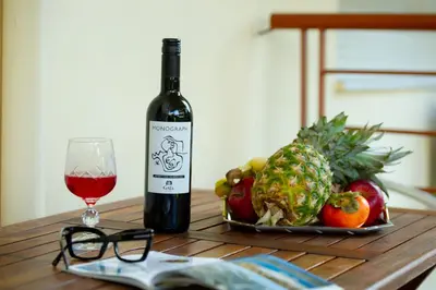 a bottle of wine next to a plate of fruit and a glass at Aqua Apartment Kallithea Athens in Athens