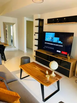 a living room with a tv and a coffee table at NEW 2BD APRT with SHARED ROOFTOP POOL E2 in Athens