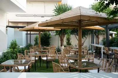 a group of tables and chairs under an umbrella at Celia Residence in Athens