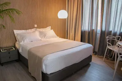 a bedroom with a bed and a table and a chair at Celia Residence in Athens
