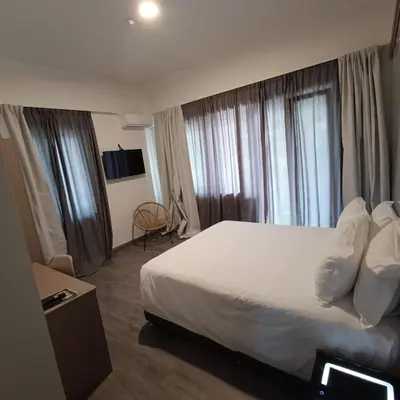 a hotel room with a large bed and windows at Celia Residence in Athens