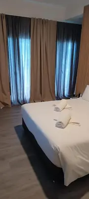 a bed in a room with blue curtains at Celia Residence in Athens