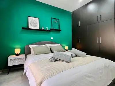a bedroom with a large bed with a green wall at Green House near Athens Center in Athens