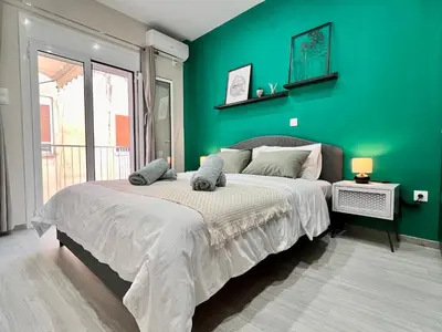 a bedroom with a large bed with a green wall at Green House near Athens Center in Athens