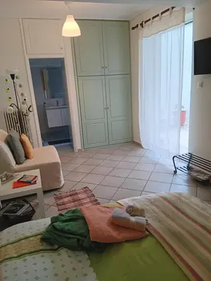 a living room with a bed and a room with a couch at Athenian Asty Guesthouse in Athens