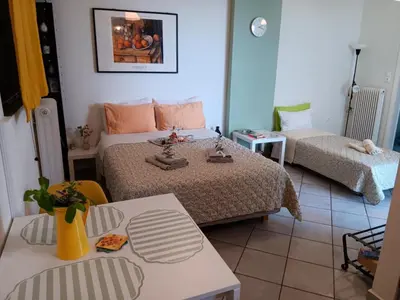 a bedroom with two beds and a table and chairs at Athenian Asty Guesthouse in Athens