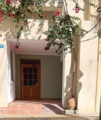 a front door of a house with pink flowers at Athenian Asty Guesthouse in Athens