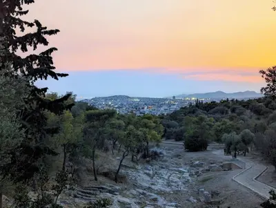a view of a city from a hill at sunset at Athenian Asty Guesthouse in Athens
