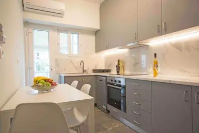 a kitchen with a bowl of fruit on a table at Alkuoni lux flat at PFaliro in Athens