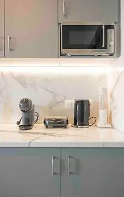 a kitchen counter with a microwave and two toasters at Alkuoni lux flat at PFaliro in Athens