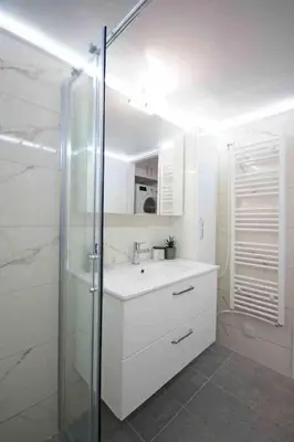 a white bathroom with a sink and a shower at Alkuoni lux flat at PFaliro in Athens