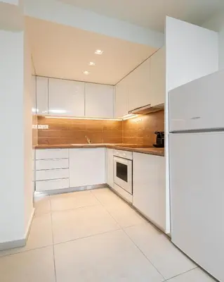 a kitchen with white cabinets and a refrigerator at Mystique One Bedroom Apartment by BluPine in Athens