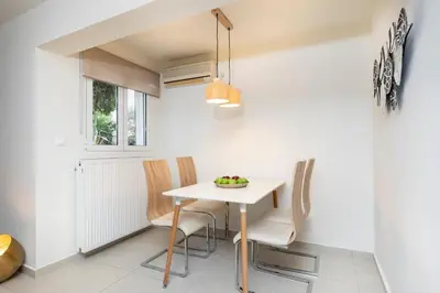 a dining room with a white table and chairs at Mystique One Bedroom Apartment by BluPine in Athens