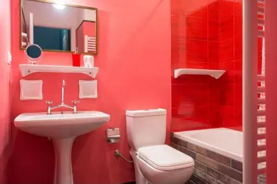 a red bathroom with a toilet and a sink at Casa de Colores, next to the metro in Athens
