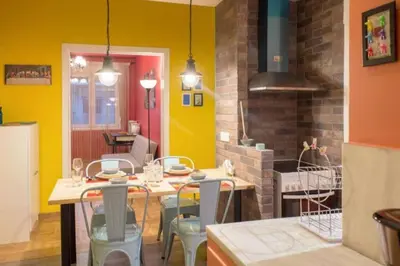 a dining room with a table and chairs and yellow walls at Casa de Colores, next to the metro in Athens