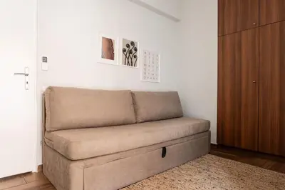 a couch sitting in a living room next to a door at Radiant Retreat in Paleo Faliro by UPSTREET in Athens