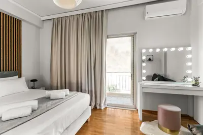 a white bedroom with a large bed and a window at Sunset Escape & Spa in Athens