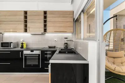 a kitchen with black cabinets and a sink at Sunset Escape & Spa in Athens