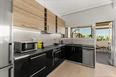 a kitchen with stainless steel appliances and black cabinets at Sunset Escape & Spa in Athens