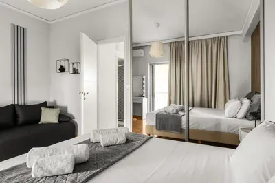 a bedroom with a large bed and a mirror at Sunset Escape & Spa in Athens