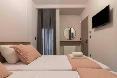 a bedroom with a large bed with a television on the wall at Blue Pearl at Glufada sea side in Athens