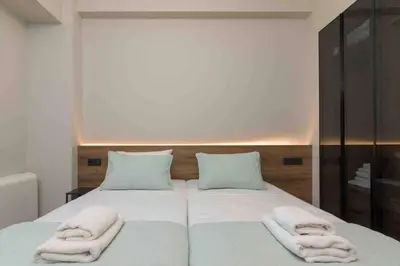 a bedroom with a bed with two towels on it at Blue Pearl at Glufada sea side in Athens