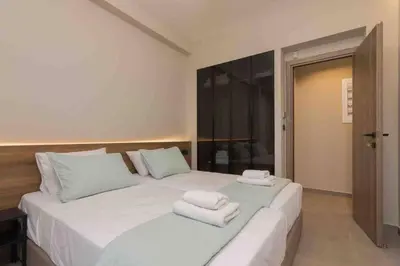 a bedroom with a large white bed with towels on it at Blue Pearl at Glufada sea side in Athens