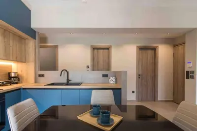 a kitchen with a sink and a counter with chairs at Blue Pearl at Glufada sea side in Athens
