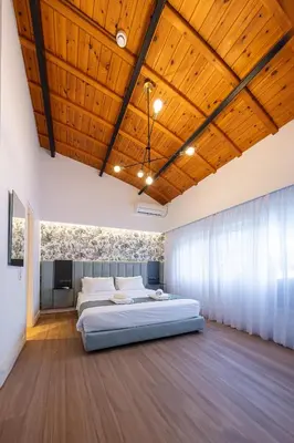 a bedroom with two beds and a wooden ceiling at Kriel Suites by LIV Homes in Athens