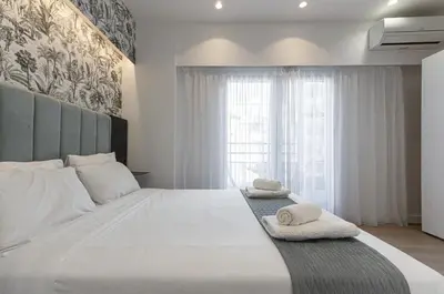 a bedroom with a large white bed with towels on it at Kriel Suites by LIV Homes in Athens