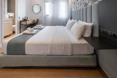 a bedroom with a large bed with a black table at Kriel Suites by LIV Homes in Athens