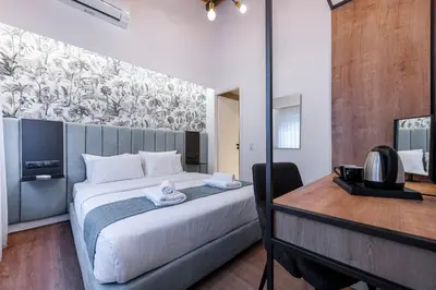 a bedroom with a bed and a desk with a television at Kriel Suites by LIV Homes in Athens