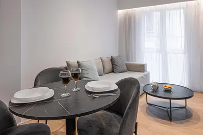 a living room with a table and two glasses of wine at Kriel Suites by LIV Homes in Athens