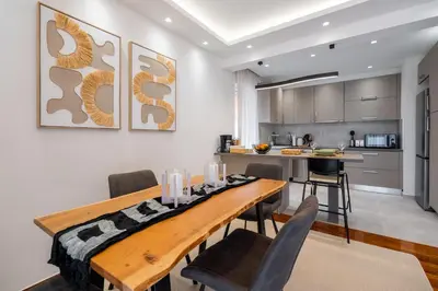 a kitchen and dining room with a wooden table and chairs at Sesilia Luxury Apartments in Athens
