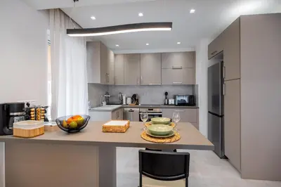 a kitchen with a table with a bowl of fruit on it at Sesilia Luxury Apartments in Athens