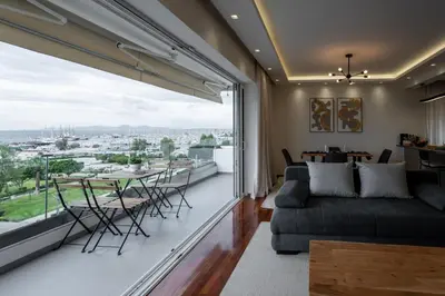 a living room with a couch and a large window at Sesilia Luxury Apartments in Athens