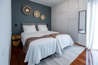 a bedroom with two beds with white comforters at Sesilia Luxury Apartments in Athens