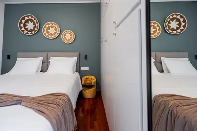 two beds in a room with blue walls and mirrors at Sesilia Luxury Apartments in Athens