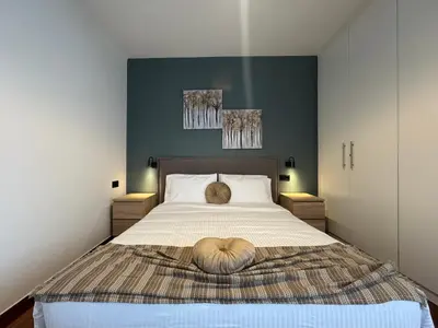 a bedroom with a large bed with a wooden headboard at Sesilia Luxury Apartments in Athens