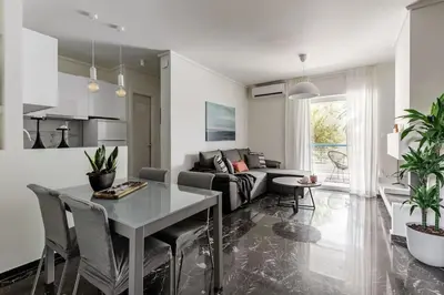 a living room with a table and a couch at Beachfront apartment in Voula w/balcony in Athens