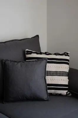 a black couch with two pillows on it at Beachfront apartment in Voula w/balcony in Athens