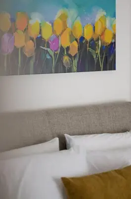 a painting of a bunch of flowers above a bed at Beachfront apartment in Voula w/balcony in Athens