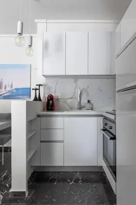 a white kitchen with white cabinets and a sink at Beachfront apartment in Voula w/balcony in Athens