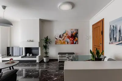 a living room with a table and a painting on the wall at Beachfront apartment in Voula w/balcony in Athens