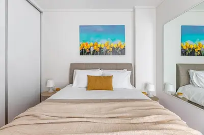 a bedroom with a large bed with yellow flowers at Beachfront apartment in Voula w/balcony in Athens
