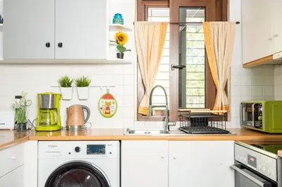 a kitchen with a sink and a washing machine at Private Garden Home next to the beach and market in Athens