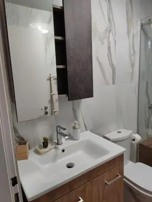 a white bathroom with a sink and a toilet at Private Garden Home next to the beach and market in Athens